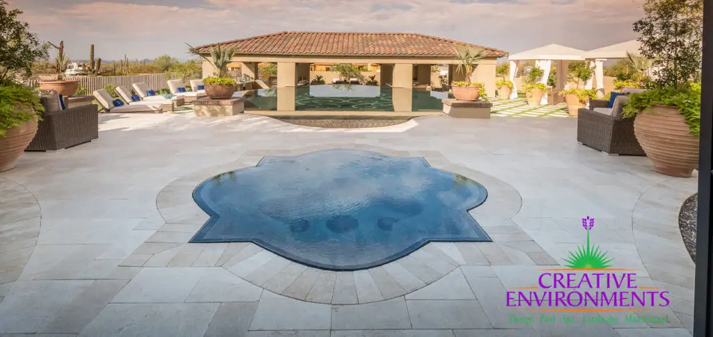 Custom backyard design with unique-shaped spa, zero-edge pool and multiple seating areas.