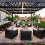 Custom backyard design with patterned metal shade structure, multiple seating areas and real grass.