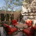 Custom backyard design with metal shutters, outdoor shelving and outdoor seating area.