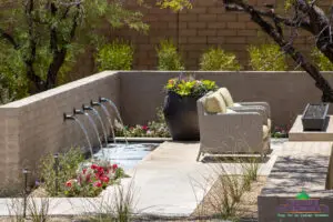 Custom backyard design with metal scupper water feature, large planter and fire table.