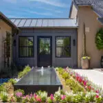 Custom backyard design with planters, metal trellis and water feature.