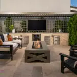 Custom backyard design with cantilevered shade structure, outdoor tv and fire table.