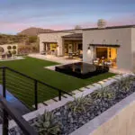 Custom backyard design with black spa and living wall with circular cutouts
