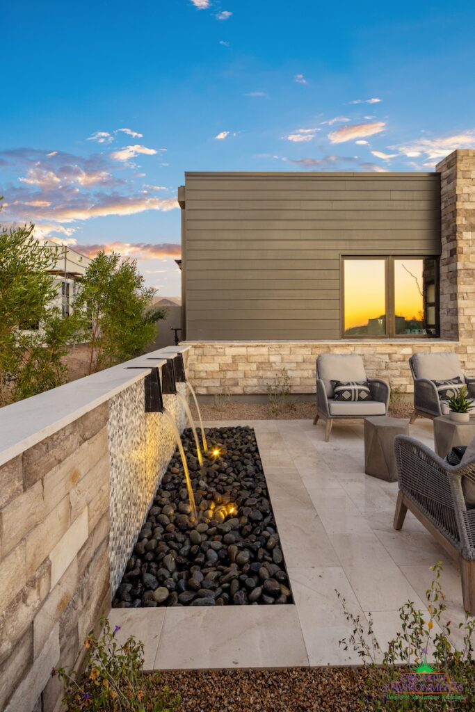 Custom front yard design with metal scupper water feature, seating area and succulents.