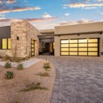 Custom front yard design with succulents, outdoor seating area and brick paver driveway.