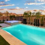 Custom backyard design with blue pool and spa, metal scupper water feature and metal dividers.