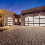 Custom front yard design with cacti, outdoor lighting and brick paver driveway.