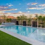 Custom backyard design with metal scupper water feature, metal fencing and baja step.