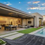 Custom backyard design with artificial turf, multiple seating areas and outdoor TV.