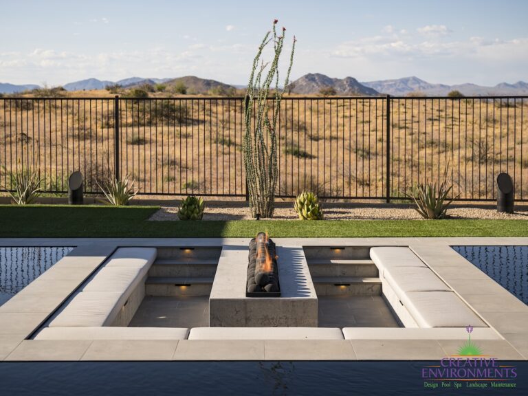 Custom backyard design with sunken fire pit, artificial turf and metal fencing.