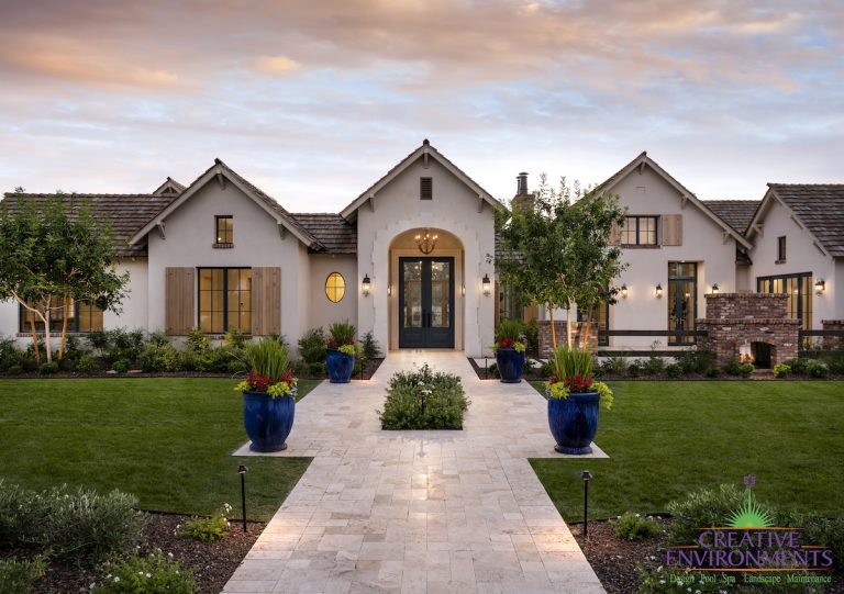 Front yard design with real grass, large potted plants and brick fireplace.
