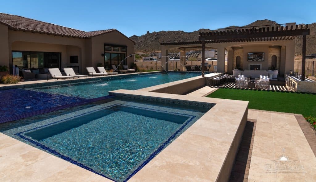 Custom backyard design with raised blue spa, baja shelf and resort-style pool.