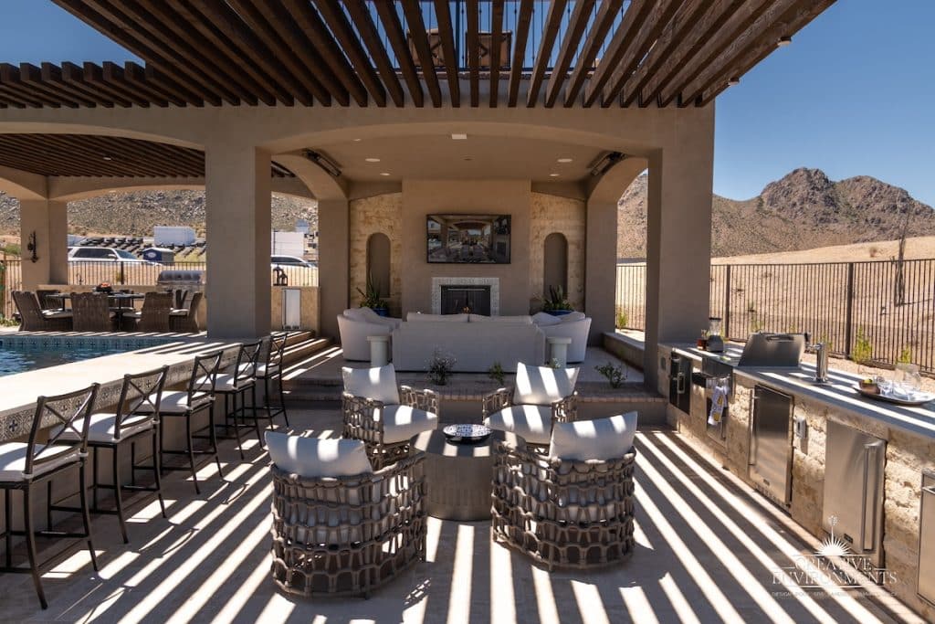 Custom backyard design with two-story shade structure, multiple seating areas and outdoor kitchen.