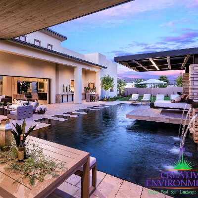 Custom backyard landscape with zero edge pool and floating bed area under covered patio
