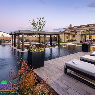 Custom backyard landscape with zero edge pool and floating covered patio area near water features