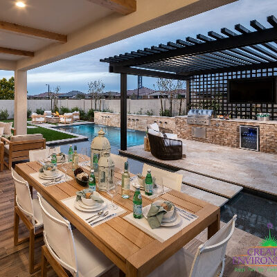 Custom backyard landscape with decorative covered patio and dining area near floating steps and swimming pool