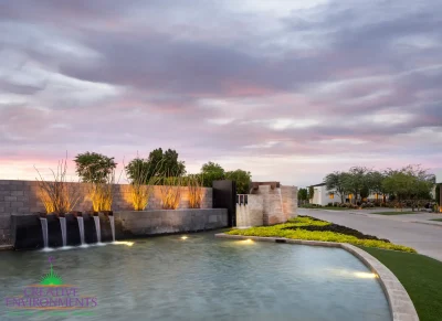 Custom community entrance with metal scupper water feature, real grass and natural stone accents.