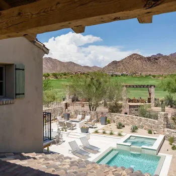 Custom backyard design with natural stone accents, multiple seating areas and blue pool and spa.