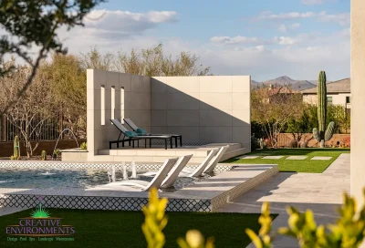 Custom backyard design with deco-tile pool, baja step and artificial turf.