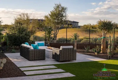 Custom backyard design with metal fencing, natural stone steps and artificial turf.