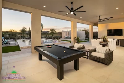 Custom backyard design with outdoor entertainment area, pool table and multiple seating areas.
