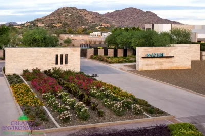 Custom community entrance with unique entrance sign, organized planting and water features.