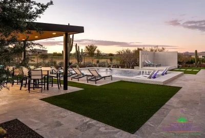 Custom backyard design with artificial turf, natural stone deck and multiple seating areas.