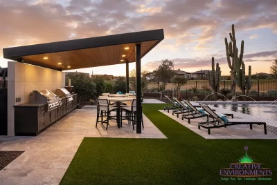 Custom backyard design with angled shade structure, cacti and multiple seating areas.