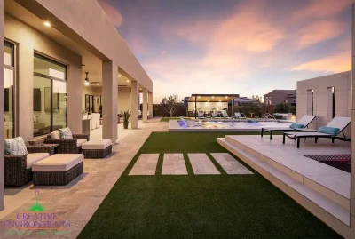 Backyard design with artificial turf, natural stone steps and angled shade structure.