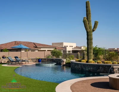 Custom backyard design with curved retention wall, cactus focal point and unique shaped pool.