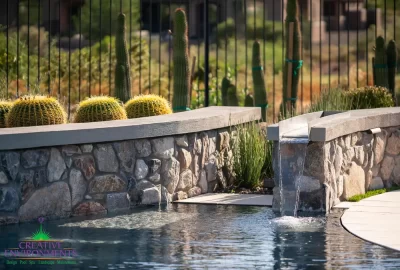 Custom backyard design with zero-edge pool, water feature into pool and curved retention wall.