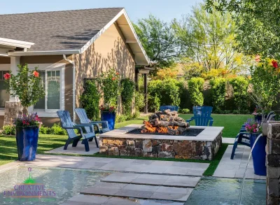 Custom square fire pit with Jesus steps, large planters and large metal trellis.