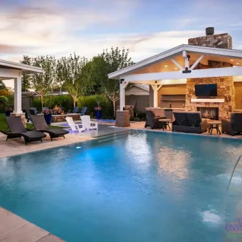 Custom backyard design with zero-edge pool, farmhouse shade structure and water columns.