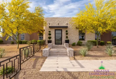 Custom front yard design with metal gence, topiaries and desert landscape design.