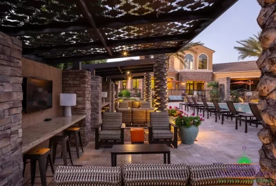 Custom community amenities with patterned metal shade structure, multiple seating areas and outdoor TVs.