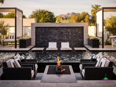 Custom backyard design with sunken fire pit, Jesus steps and black water wall into pool.