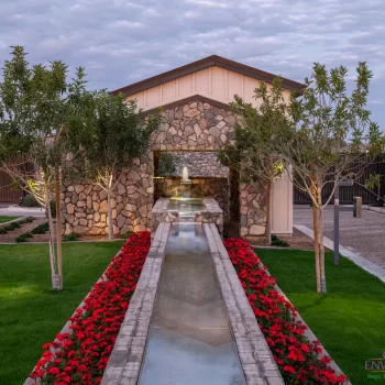 Custom community amenities with linear water feature, tree uplighting and organized planting.