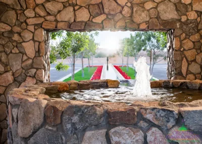 Custom community entrance with long water feature, water fountain and natural stone accents.