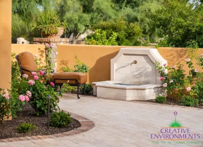 Backyard design with water feature and multiple plants.