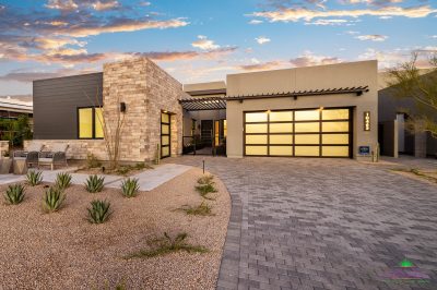 Custom front yard design with succulents, outdoor seating area and brick paver driveway.