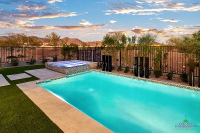 Custom backyard design with blue pool and spa, metal scupper water feature and metal dividers.