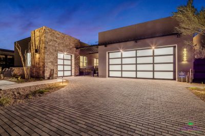 Custom front yard design with cacti, outdoor lighting and brick paver driveway.