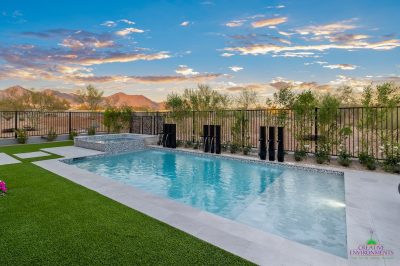 Custom backyard design with metal scupper water feature, metal fencing and baja step.