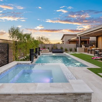 Custom backyard design with raised spa, blue pool and metal scupper water feature.