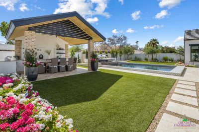 Custom backyard design with deco-tile pool, outdoor shade structure and annuals.
