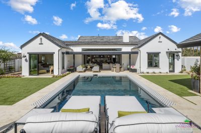 Custom backyard design with large pool, multiple grassy areas and deco-tile pool.