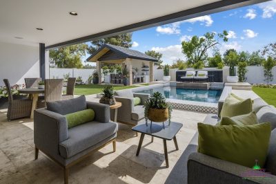 Custom backyard design with multiple seating areas, black water wall and deco-tile pool.