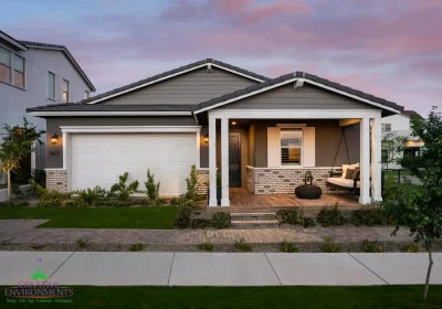 Custom front yard design with artificial turf, organized planting and hanging porch swing.