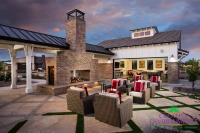 Custom community amenities with patterned turf, large fireplace with chimney and multiple outdoor seating areas.