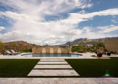 Custom backyard design with natural stone steps, unique shaped pool and multiple seating areas.